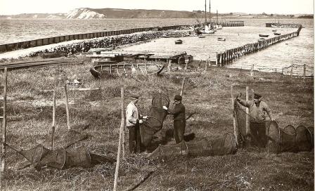 Fiskere bøder garn på stejlepladsen på Kulhus havn cirka 1930.